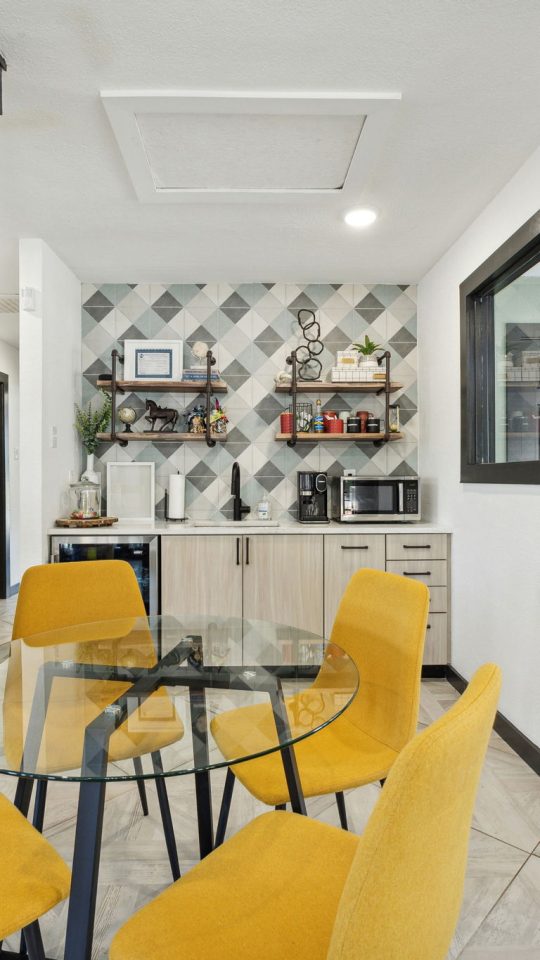 a dining room with yellow chairs and a table at The Wilder