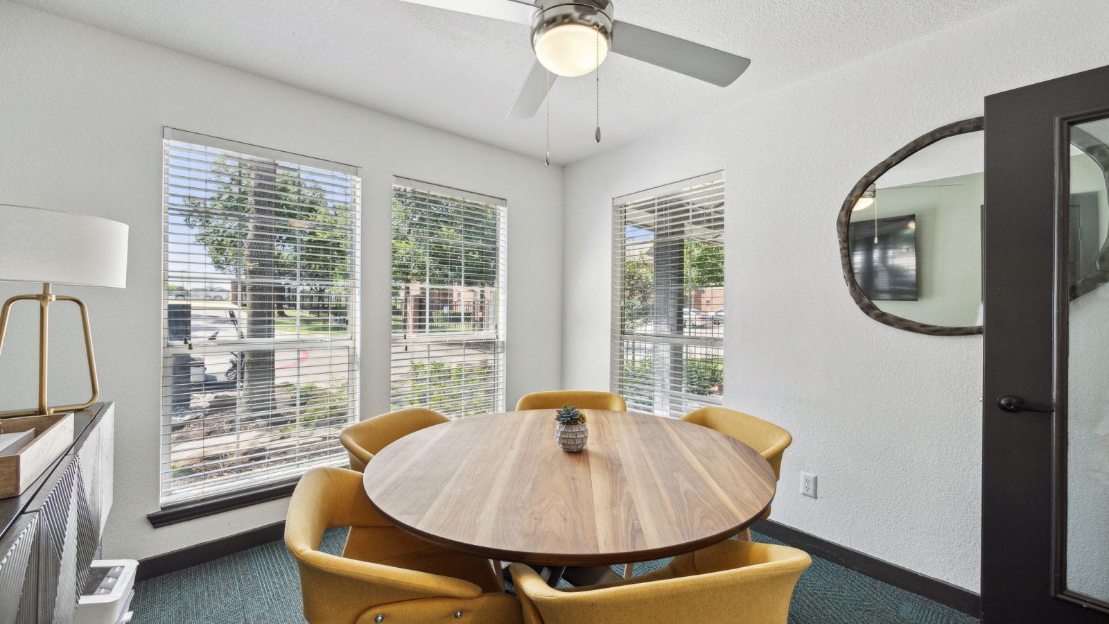 a dining room with a table and chairs and a ceiling fan at The Wilder